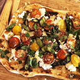Grilled Pizza With Grilled Tomatoes, Asparagus, Goat Cheese, and Marcona Almonds Recipe